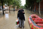 Dos personas se abrazan en una calle inundada, después de que las fuertes lluvias azotaran la región italiana de Emilia Romaña, en Faenza, Italia, el 18 de mayo de 2023. © Claudia Greco / Reuters